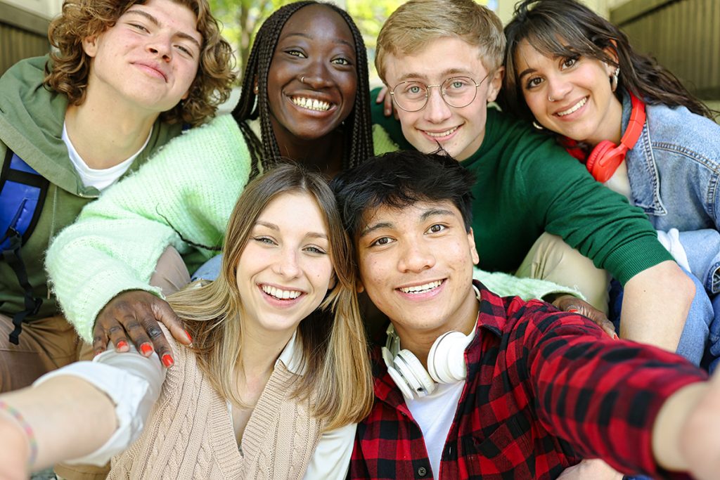 Multi-ethnic group of students doing selfie outside of the school