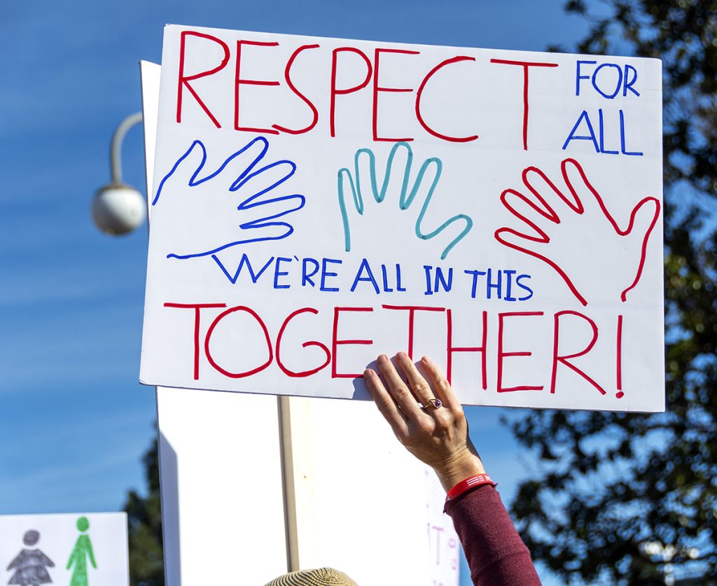 Close-up of a hand-drawn sign proclaiming, "Respect for All. We're All in this Together!"
